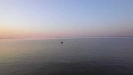 Abendansicht-Aus-Der-Luft-Auf-Das-Weite-Meer,-Einsames-Boot-Und-Die-Skyline