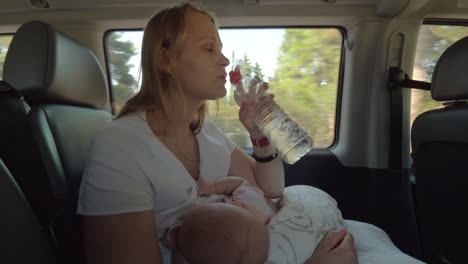 Mutter-Trinkt-Wasser-Und-Stillt-Ihr-Baby-Im-Auto