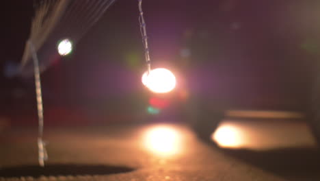 Car-with-bright-headlights-driving-at-night