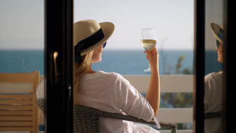 Mujer-Relajándose-En-Soledad,-Bebiendo-Vino-Y-Disfrutando-De-Las-Vistas-Al-Mar.