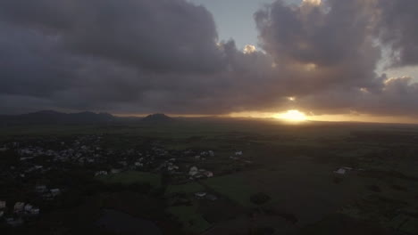 Aerial-view-of-Mauritius-Island-forests-farm-fields-and-hills-against-sunset-sky-and-pink-clouds