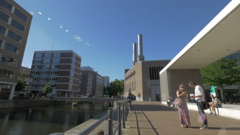 View-of-modern-city-buildings-and-tourists-walking-about-canal-Rotterdam-Netherlands