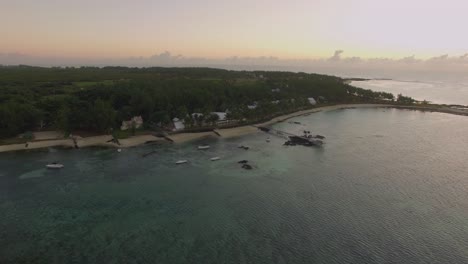 Vista-Aérea-Del-Agua-Azul-Del-Océano-Con-Olas,-Corales-Y-Plantas-Acuáticas,-Cámara-Que-Se-Mueve-A-La-Costa-De-La-Isla-Mauricio