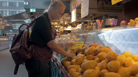 Frau-Kauft-Mango-In-Der-Markthalle-Rotterdam