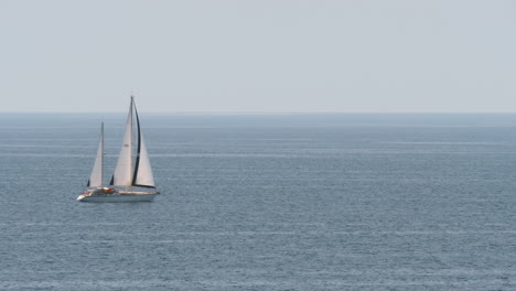 Yacht-with-sails-in-quiet-blue-sea