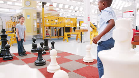 Three-kids-playing-giant-chess-at-a-science-activity-centre