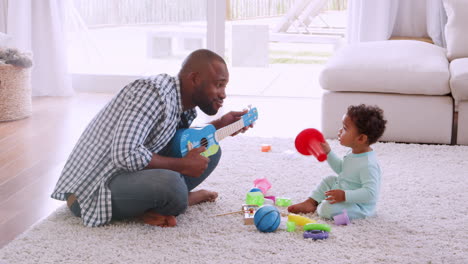 Young-black-father-playing-with-his-son-in-sitting-room