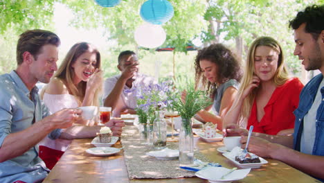 Six-young-friends-dining-at-a-table-outdoors