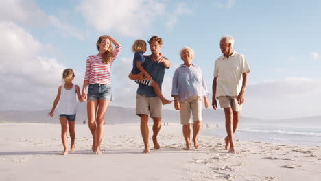 Familie-Mit-Mehreren-Generationen-Im-Sommerurlaub,-Die-Am-Strand-Entlang-Spaziert