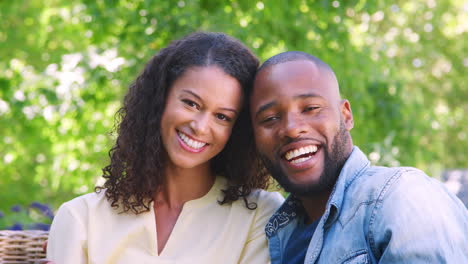 Happy-young-black-couple-sitting-and-embracing-in-the-garden