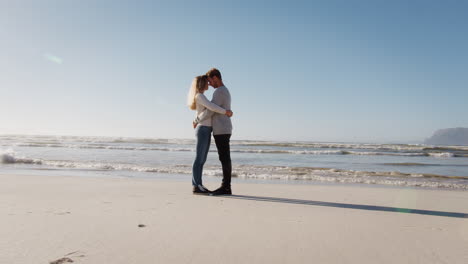 Loving-Couple-Embracing-On-Winter-Beach-Together