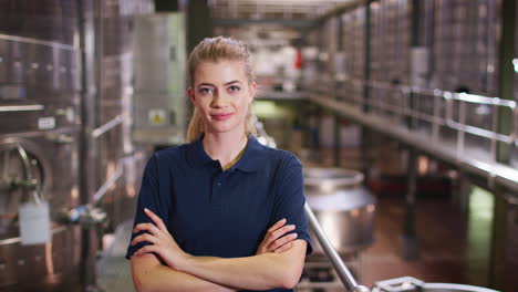 Young-white-woman-working-at-wine-factory-walking-into-focus