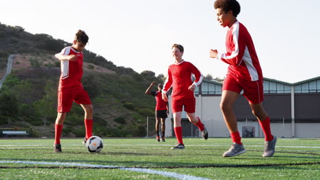 Group-Of-Male-High-School-Students-With-Coach-Playing-In-Soccer-Team