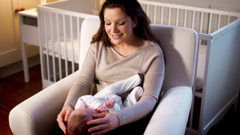 Loving-Mother-Playing-With-Newborn-Baby-Son-In-Nursery-At-Home