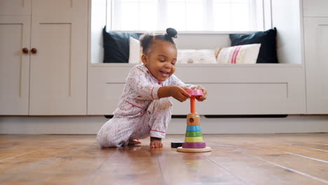 Smiling-Female-Toddler-At-Home-Playing-With-Wooden-Stacking-Toy
