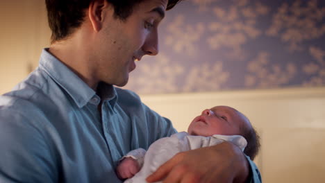 Loving-Father-Cuddling-Newborn-Baby-Son-At-Home-In-Nursery