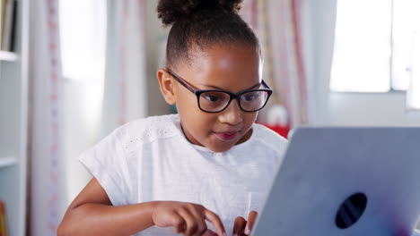 Junges-Mädchen-Mit-Brille-Sitzt-Am-Schreibtisch-Im-Schlafzimmer-Und-Benutzt-Einen-Laptop
