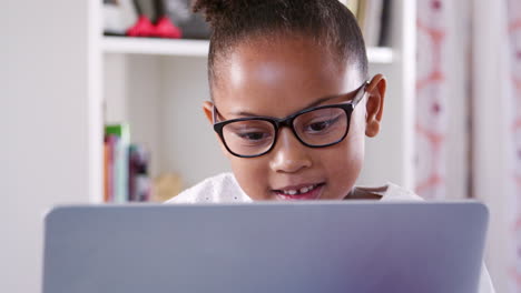 Junges-Mädchen-Mit-Brille-Sitzt-Am-Schreibtisch-Im-Schlafzimmer-Und-Benutzt-Einen-Laptop