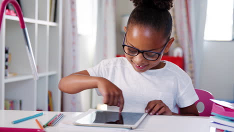 Junges-Mädchen-Mit-Brille-Sitzt-Am-Schreibtisch-Im-Schlafzimmer-Und-Spielt-Ein-Spiel-Auf-Einem-Digitalen-Tablet