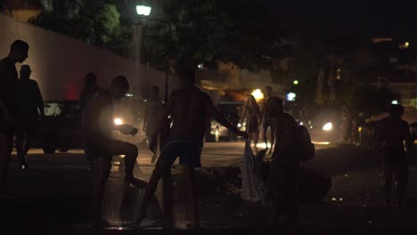 Several-men-taking-beach-shower-at-night