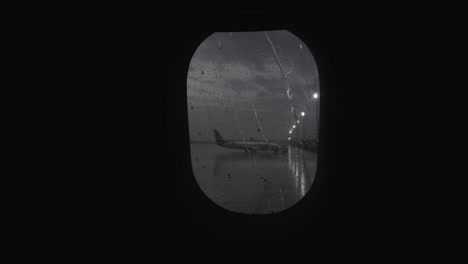 Illuminator-with-rain-streaks-view-to-airport-from-moving-plane