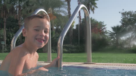 Happy-child-splashing-water-in-swimming-pool