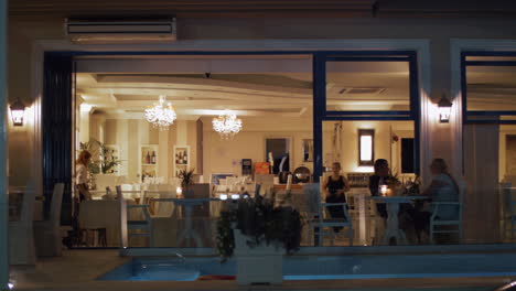 Vista-Al-Restaurante-Vacío-Con-Dos-Camareras-Por-La-Noche.