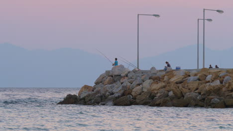 Menschen-Angeln-Und-Entspannen-Am-Pier-Im-Meer-Abendszene-Griechenland