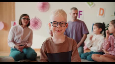 Retrato-De-Un-Niño-Feliz-En-Edad-Preescolar-Con-Cabello-Blanco-Y-Gafas-Que-Mira-A-La-Cámara-Y-Sonríe-En-El-Contexto-De-Su-Primera-Lección-En-Preparación-Para-La-Escuela.