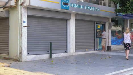 Straße-Mit-Gehenden-Menschen-Und-Mann,-Der-Geldautomaten-Benutzt,-Griechenland