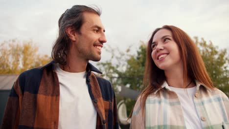 A-guy-with-long-hair-strokes-his-girlfriend's-face-with-his-hands.-Rest-in-the-country-house