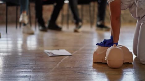 Close-up-shooting-from-the-bottom:-A-professional-female-doctor-conducts-a-practical-training-in-medical-care,-performing-artificial-respiration-on-a-mannequin-for-the-public