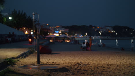 Frente-Al-Mar-Con-Playa-Y-Gente-En-La-Ciudad-Turística-Nocturna-De-Grecia