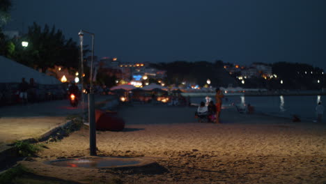 Direkt-Am-Meer-Mit-Strand-Und-Menschen-Im-Nächtlichen-Ferienort-Griechenland