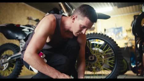 Close-up-shot:-a-man-with-short-hair-in-a-gray-T-shirt-selects-the-necessary-tools-to-begin-repairing-the-bike