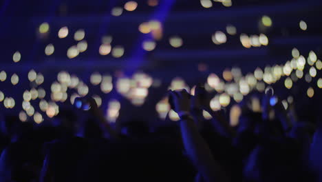 Crowd-of-music-fans-with-lights-in-dark-concert-hall