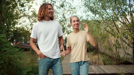 Una-Chica-Y-Su-Novio-De-Pelo-Rizado-Con-Una-Camiseta-Blanca-Caminan-Y-Hablan-Solos-Entre-Sí-En-La-Casa-De-Campo.