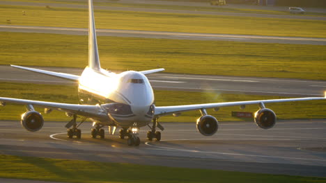 British-cargo-airplane-driving-to-runway-at-sunset