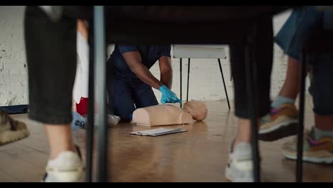 Bottom-view:-A-Black-male-doctor-in-a-blue-uniform-conducts-a-training-practical-training-on-artificial-respiration-together-with-his-assistant-in-a-white-uniform