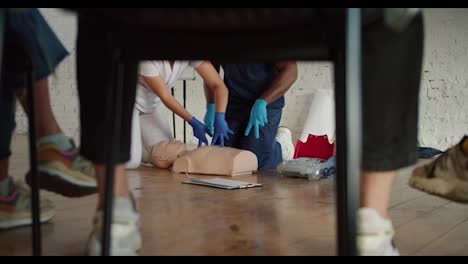 Bottom-view:-A-Black-male-doctor-in-a-blue-uniform,-together-with-his-assistant,-a-female-nurse-in-a-white-uniform,-conducts-artificial-respiration-training