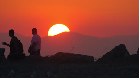 Men-walking-against-sunset-and-mountain-background