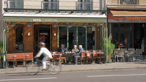 Calle-En-París-Con-Pequeños-Cafés-Al-Borde-De-La-Carretera,-Francia.