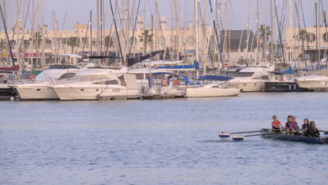 Rowing-boat-sailing-in-quay-with-yachts-Alicante-Spain