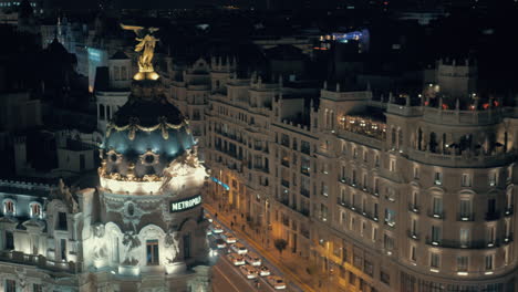 Paisaje-Urbano-Nocturno-De-Madrid-Con-Edificio-Metrópolis-Y-Tráfico-En-La-Calle-Gran-Vía