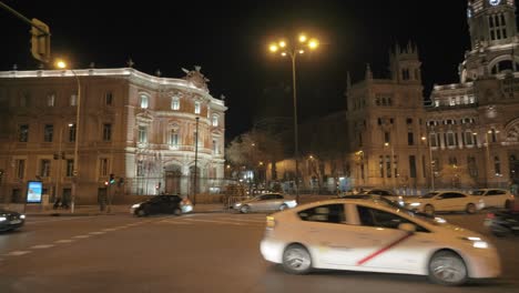 Verkehr-Auf-Der-Plaza-Cibeles-Mit-Nachtansicht-Des-Rathauses-Von-Madrid,-Spanien