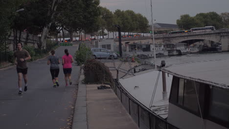 Straße-Am-Flussufer-Mit-Einigen-Leuten,-Die-Abends-In-Paris,-Frankreich,-Joggen-Gehen