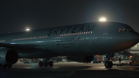 Aircraft-tow-tractor-pulling-Aeroflot-plane-at-winter-night-Moscow-Russia