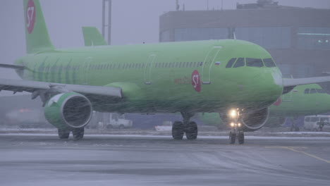 Plane-of-S7-Airlines-driving-on-runway-at-Domodedovo-Airport-view-in-snowfall