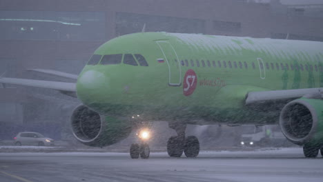 Airplane-of-S7-Airlines-driving-to-runway-in-snowfall-Moscow