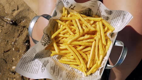 Woman-eating-appetizing-golden-crunchy-French-fries-outdoor